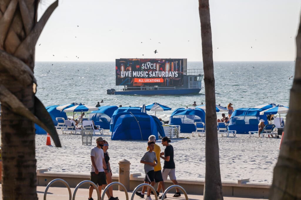Outdoor advertisement of Slyce Pizza at Clearwater Beach.
