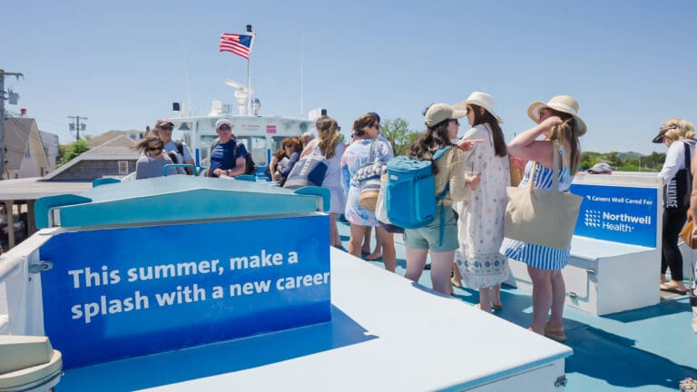 Passengers de-boarding fire island ferry with northwell health being advertised
