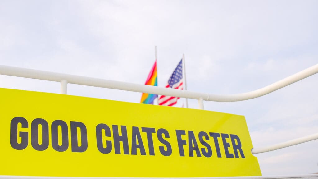 two flags and a yellow advertisement saying good chats faster