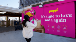 Woman taking a photo of a terminal domination ad in Fire Island.