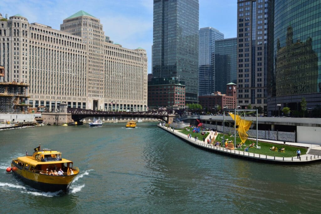Chicago Water Taxi passing River Theater steps and the AMA Plaza area—prime real estate for advertisers looking to reach office workers, tourists, and residents along the river.